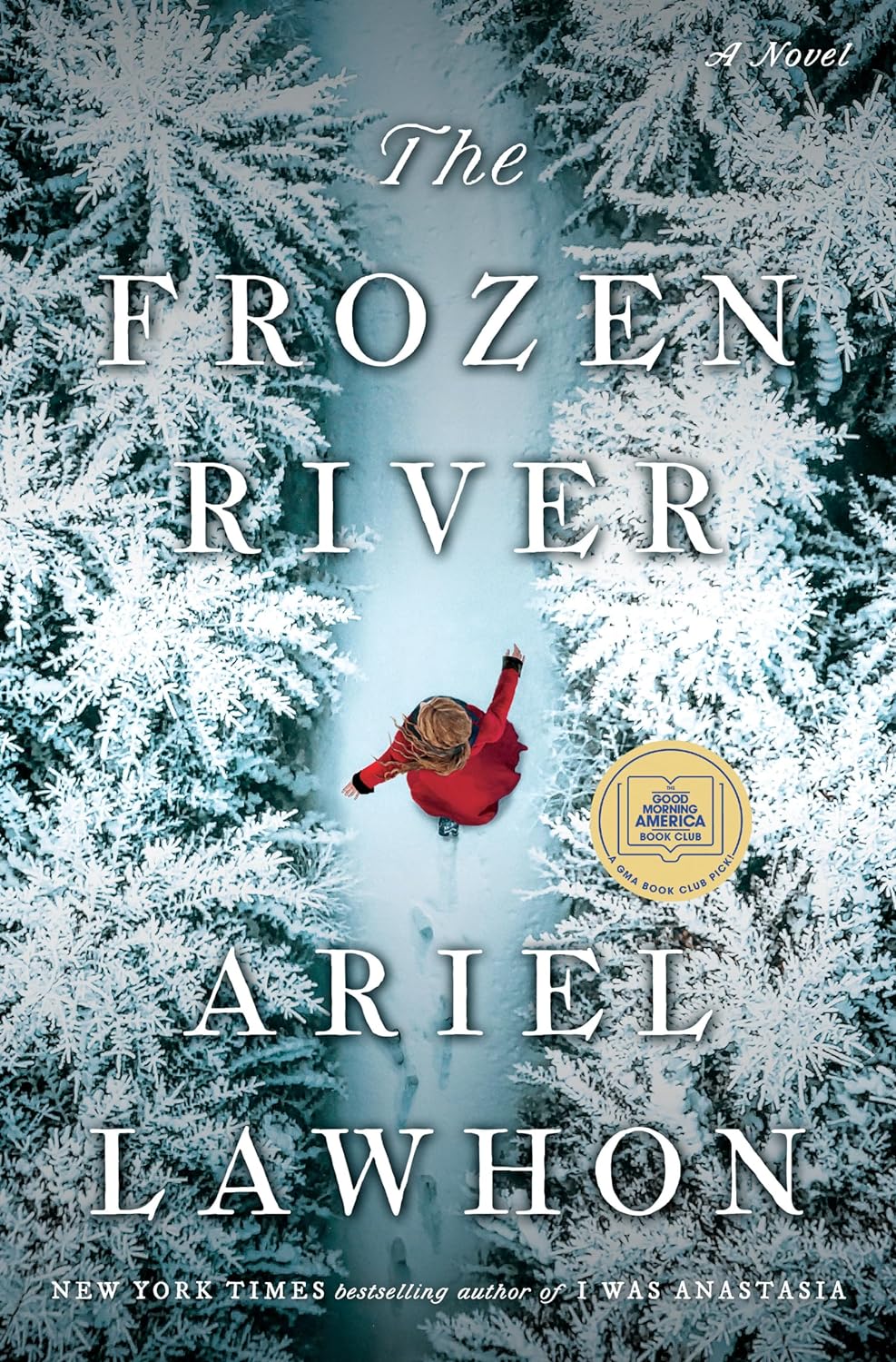 Book cover for The Frozen River by Ariel Lawhon, showing an aerial view of a woman dressed in a red coat walking down a snow-covered path in the middle of a pine forest, the trees covered with snow.