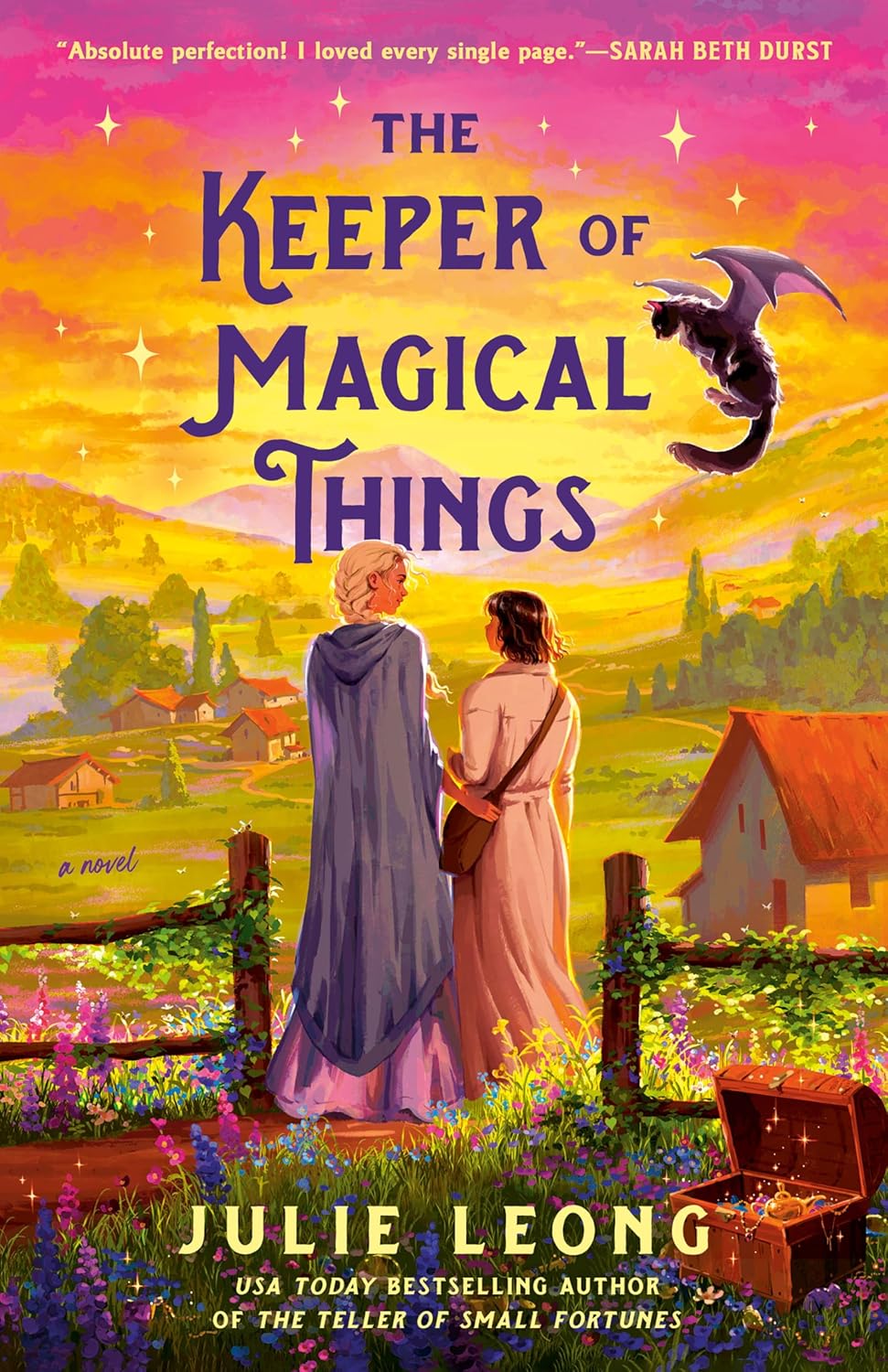 Book cover for The Keeper of Magical Things by Julie Leong. The title is set on a background of a bucolic country scene with hills in the background, a sunset, red-roofed small building, green fields and trees. Two women look towards the sunset, one with blonde hair tied in a fishtail braid; the other is brown-haired and shorter. They're standing in a fence opening surrounded by purple and blue flowers. Above them a cat flies with dragon wings unfurled, fluffly tail below.